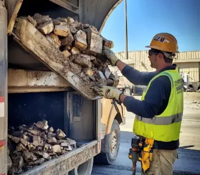 construction-worker-yellow-safety-vest-hard-hat-stands-near-truck-bed-filled-with-rubble_1352884-19936